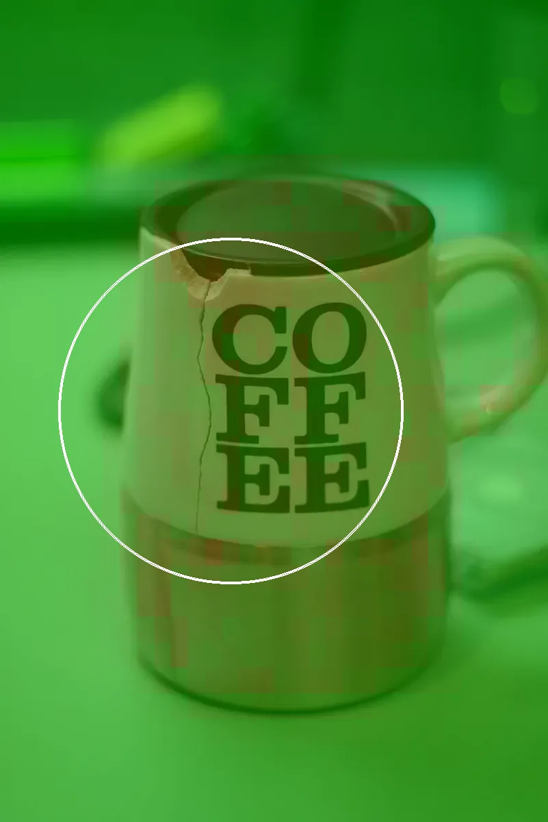 The edited mug with V3's heatmap as the dashboard draws it. The strongest cells, marked by the white ring, sit near the crack, but they peak at 47.8%, below the level at which the heatmap marks a region as edited, so the overlay stays green.